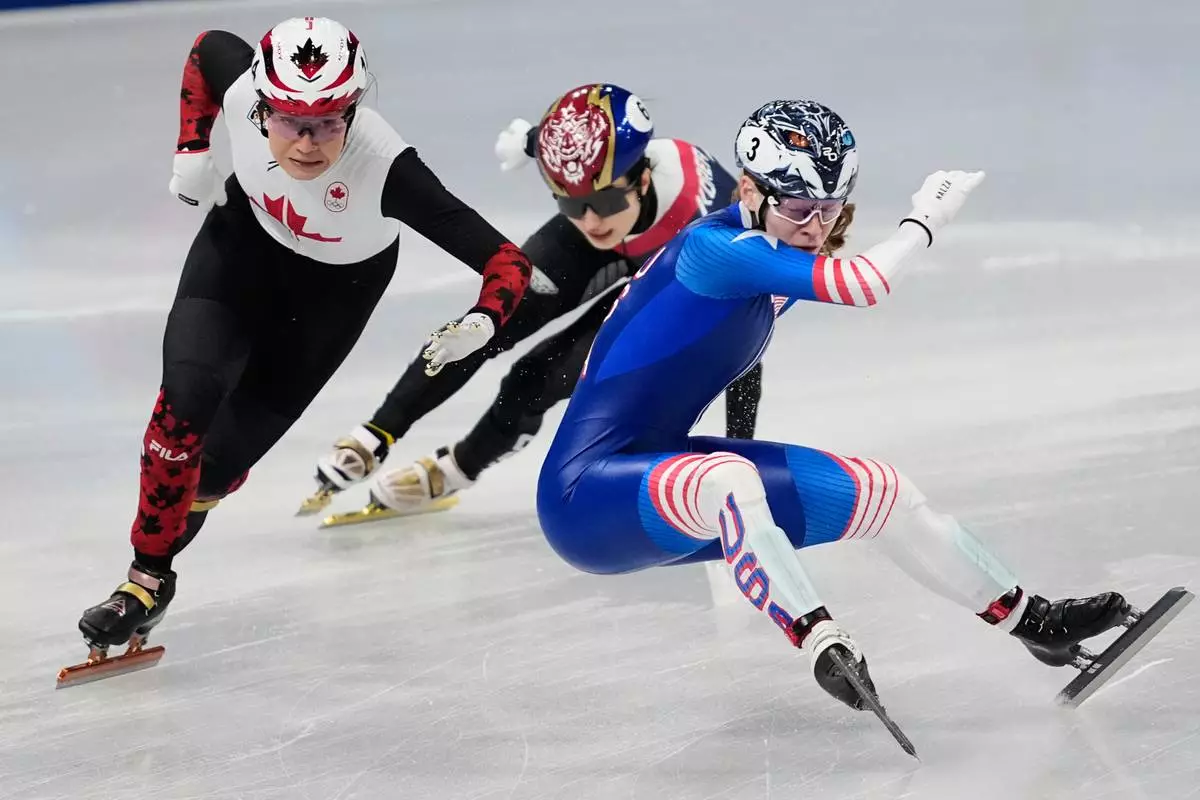 Corinne Stoddard, right, of the United States crashes as Courtney Sarault of Canada avoids her while competing in the team mixed relay short track speed skating at the 2026 Winter Olympics, in Milan, Italy, Tuesday, Feb. 10, 2026. (AP Photo/Ashley Landis)
