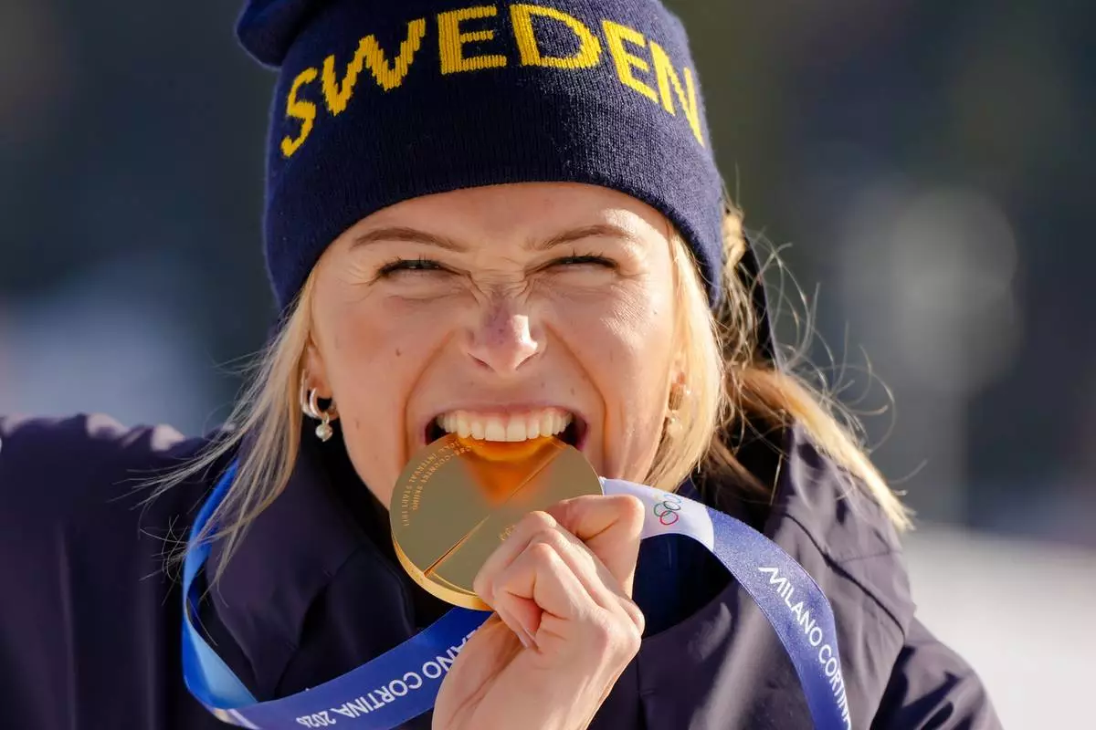 Frida Karlsson, of Sweden, poses after winning the gold medal in the cross country skiing women's 10km interval start free at the 2026 Winter Olympics, in Tesero, Italy, Thursday, Feb. 12, 2026. (AP Photo/Kirsty Wigglesworth)