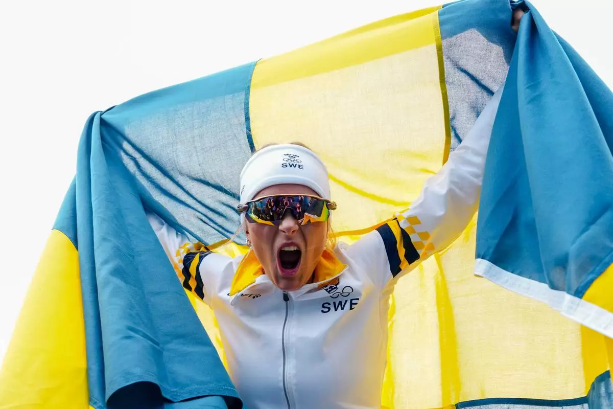 Frida Karlsson, of Sweden, celebrates after finishing the cross country skiing women's 10km interval start free at the 2026 Winter Olympics, in Tesero, Italy, Thursday, Feb. 12, 2026. (AP Photo/Kirsty Wigglesworth)