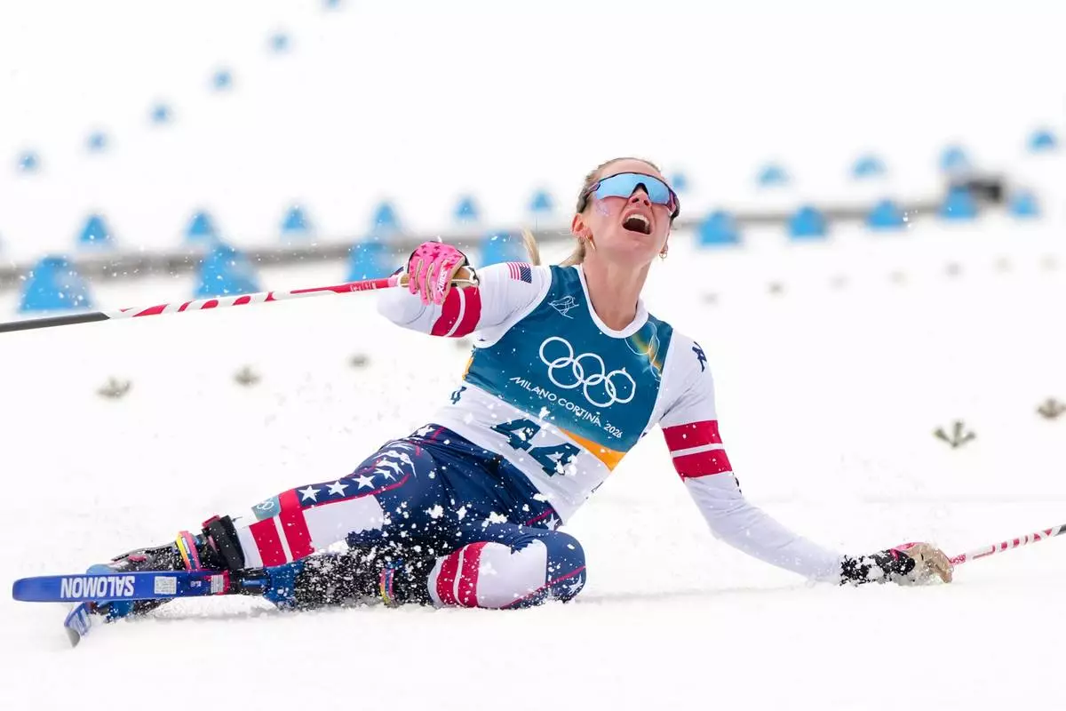Jessie Diggins, of the United States, falls to the ground after crossing the finish line in the cross country skiing women's 10km interval start free at the 2026 Winter Olympics, in Tesero, Italy, Thursday, Feb. 12, 2026. (AP Photo/Kirsty Wigglesworth)