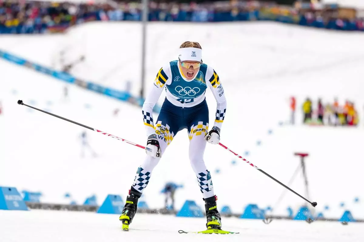 Frida Karlsson, of Sweden, crosses the finish line in the cross country skiing women's 10km interval start free at the 2026 Winter Olympics, in Tesero, Italy, Thursday, Feb. 12, 2026. (AP Photo/Kirsty Wigglesworth)