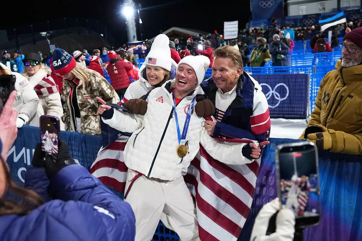 Gold medalist United States' Alex Ferreira, center, celebrates alongside US Ski Team CEO Sophie Goldschmidt, left, and team board of trustee member Ronald Kruszewski after the men's freestyle skiing halfpipe finals at the 2026 Winter Olympics, in Livigno, Italy, Friday, Feb. 20, 2026. (AP Photo/Gregory Bull)