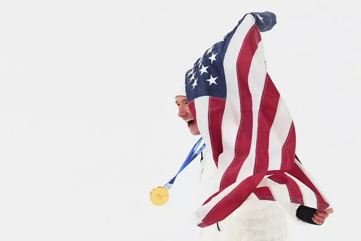 Gold medalist United States' Alex Ferreira celebrates with an American flag after winning the men's freestyle skiing halfpipe finals at the 2026 Winter Olympics, in Livigno, Italy, Friday, Feb. 20, 2026. (AP Photo/Lindsey Wasson)