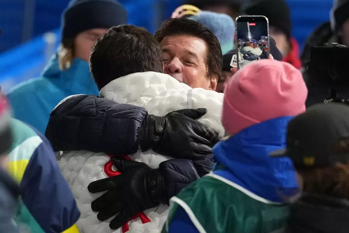 Gold medalist United States' Alex Ferreira, left, hugs his dad, Marcelo Ferreira, after winning the men's freestyle skiing halfpipe finals at the 2026 Winter Olympics, in Livigno, Italy, Friday, Feb. 20, 2026. (AP Photo/Lindsey Wasson)