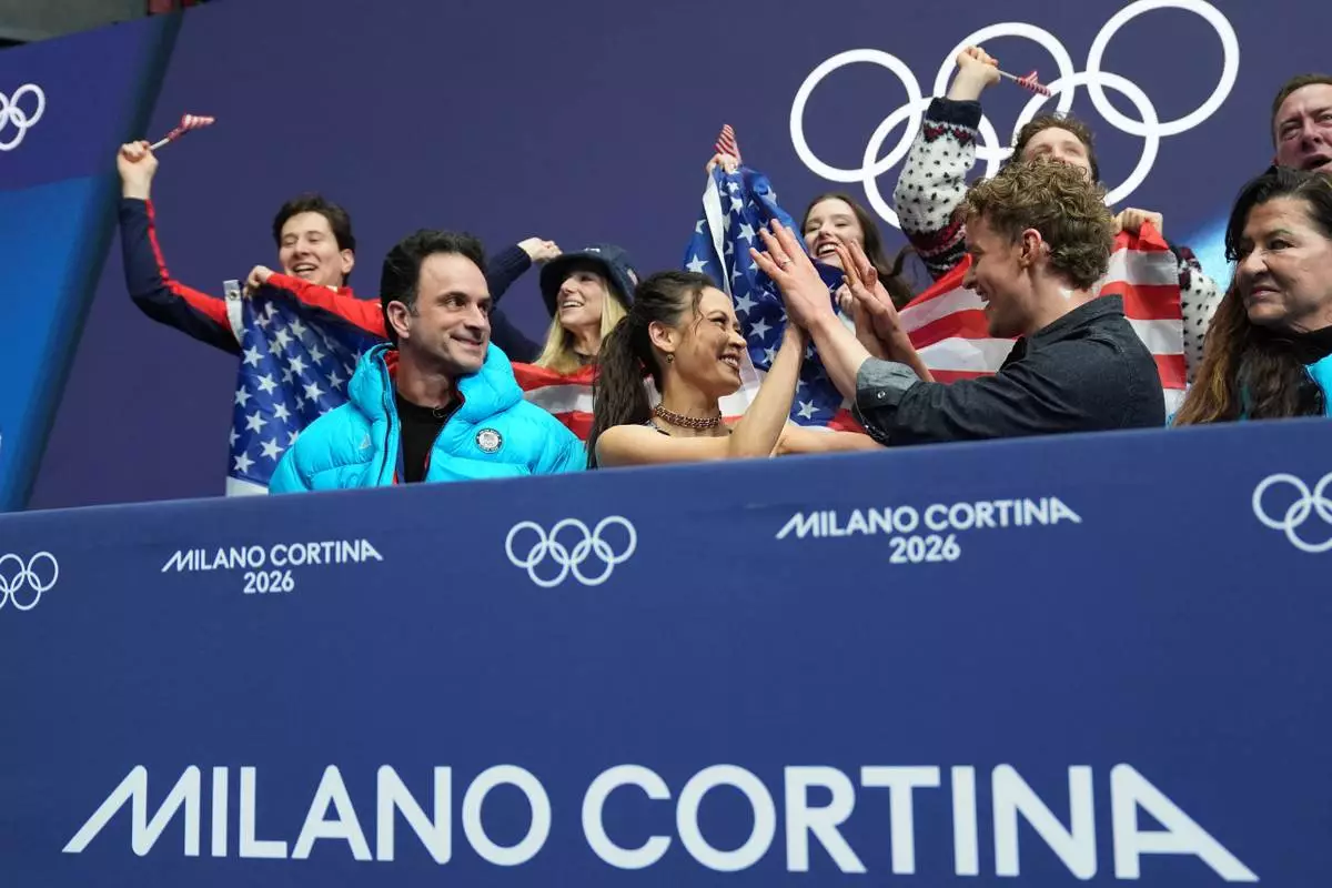 Madison Chock and Evan Bates of the United States react to their scores after competing during the figure skating ice dance team event at the 2026 Winter Olympics, in Milan, Italy, Friday, Feb. 6, 2026. (AP Photo/Stephanie Scarbrough)