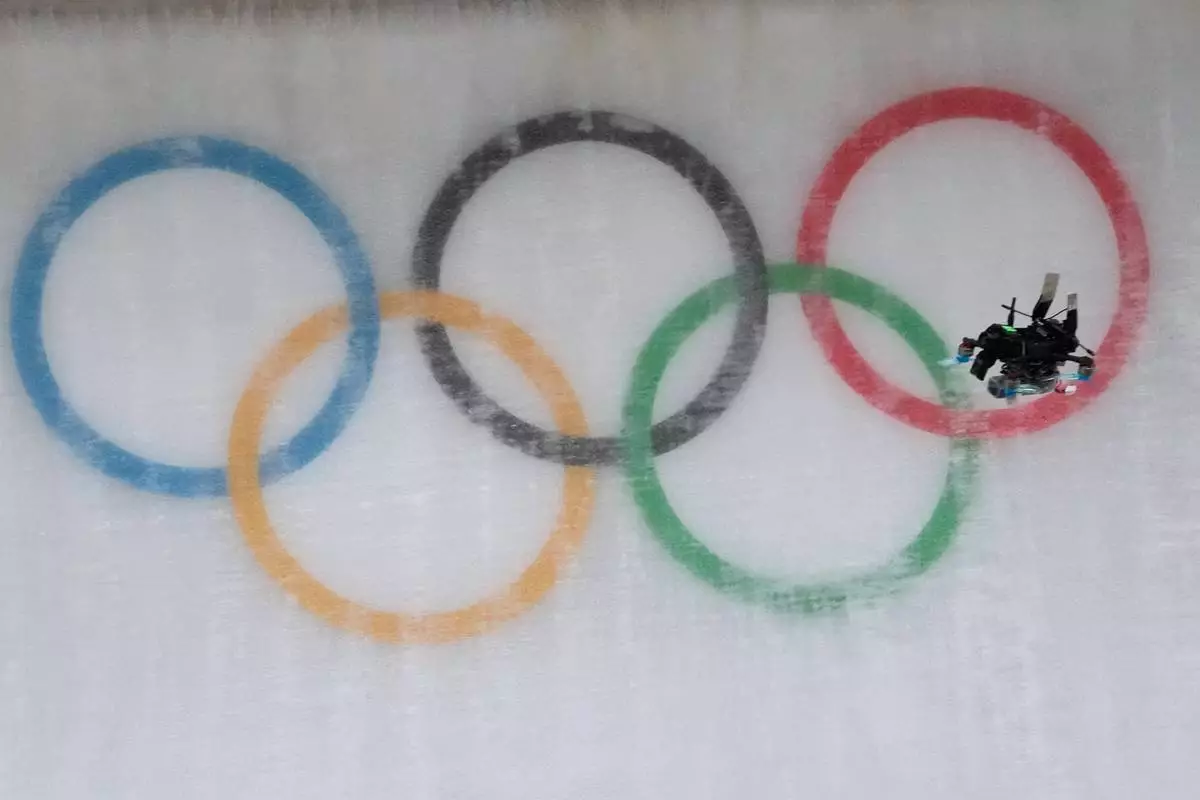 A drone flies down the track during a men's single luge run at the 2026 Winter Olympics, in Cortina d'Ampezzo, Italy, Sunday, Feb. 8, 2026. (AP Photo/Aijaz Rahi)