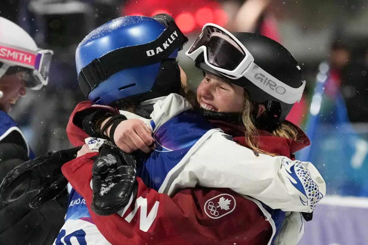 Silver medalist China's Eileen Gu, left, hugs gold medalist Canada's Megan Oldham after the women's freestyle skiing big air finals at the 2026 Winter Olympics, in Livigno, Italy, Monday, Feb. 16, 2026. (AP Photo/Lindsey Wasson)