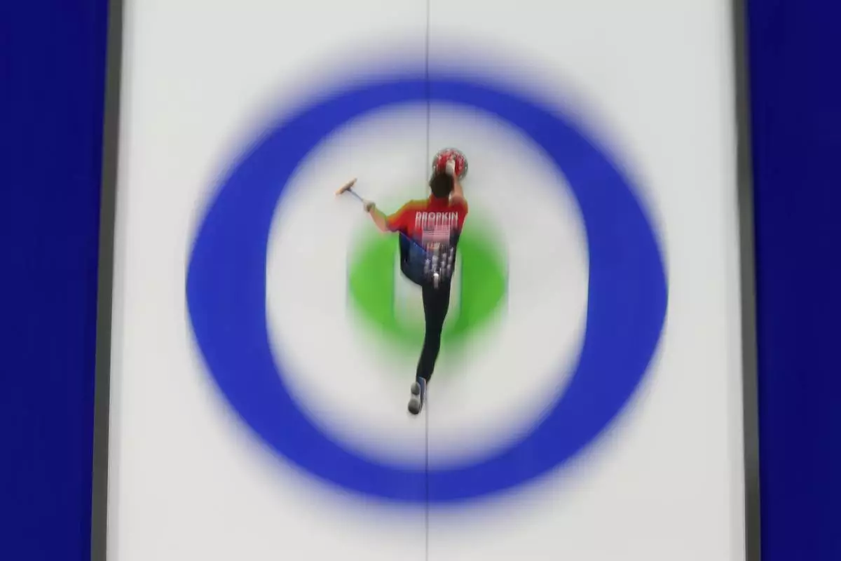 United States' Korey Dropkin delivers a stone against Italy during a curling mixed doubles session at the 2026 Winter Olympics, in Cortina d'Ampezzo, Italy, Monday, Feb. 9, 2026. (AP Photo/David J. Phillip)