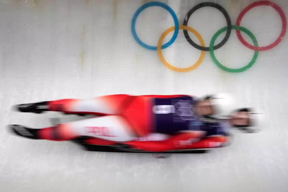 Poland's Nikola Domowicz and Dominika Piwkowska, right, slide down the track during a women's doubles luge training session at the 2026 Winter Olympics, in Cortina d'Ampezzo, Italy, Monday, Feb. 9, 2026. (AP Photo/Aijaz Rahi)
