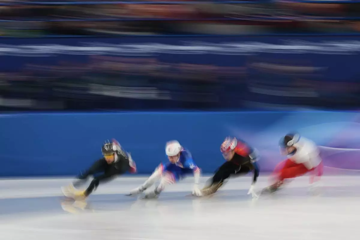 From left to right, Roberts Kruzbergs of Latvia, Brandon Kim of the United States, Sun Long of China and Michal Niewinski of Poland compete in the men's 1000 meter short track speed skating heats at the 2026 Winter Olympics, in Milan, Italy, Tuesday, Feb. 10, 2026. (AP Photo/Francisco Seco)