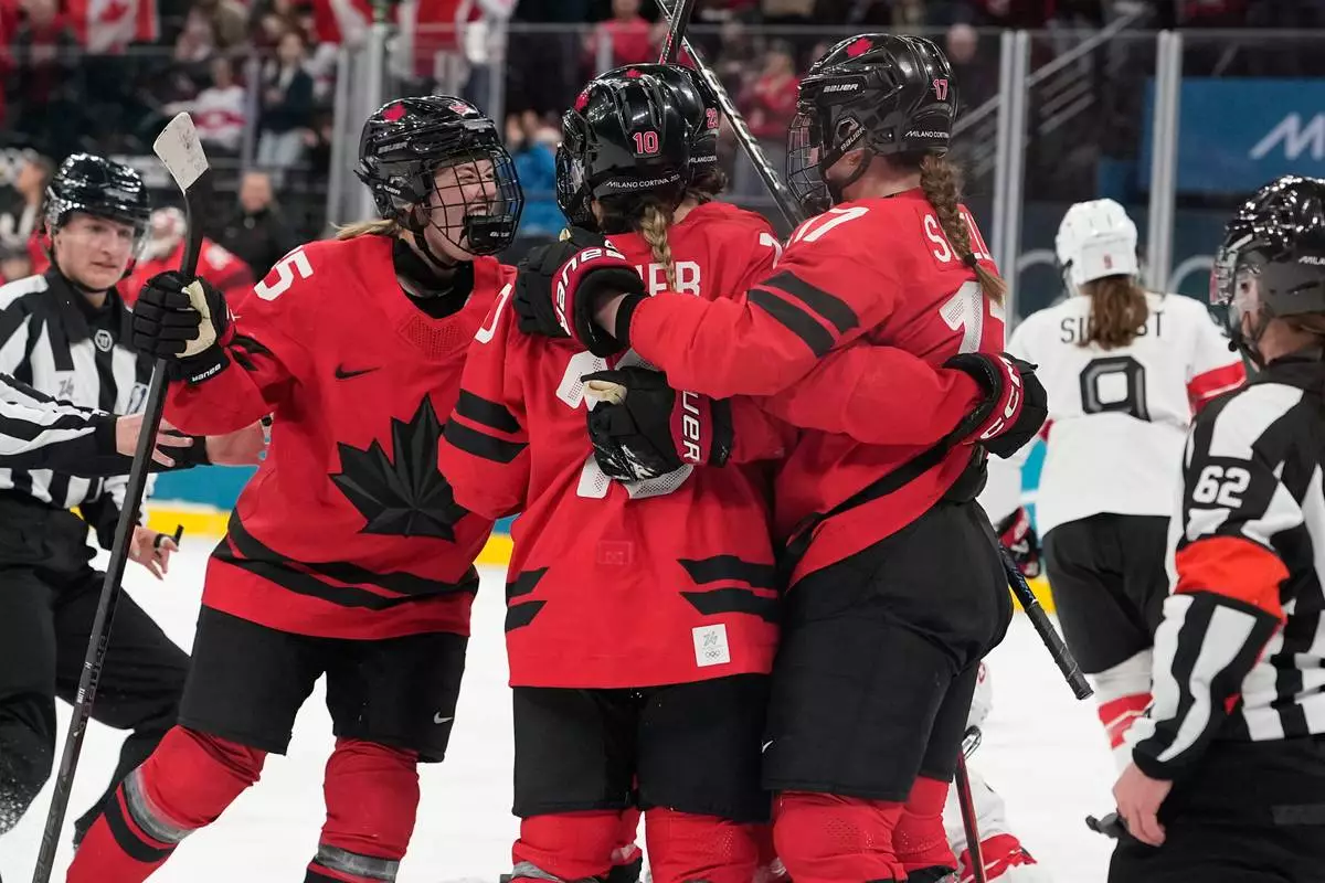 Canada players celebrate after Canada's Marie-Philip Poulin (29) scored her side's second goal during a women's ice hockey semifinal game between Canada and Switzerland at the 2026 Winter Olympics, in Milan, Italy, Monday, Feb. 16, 2026. (AP Photo/Hassan Ammar)