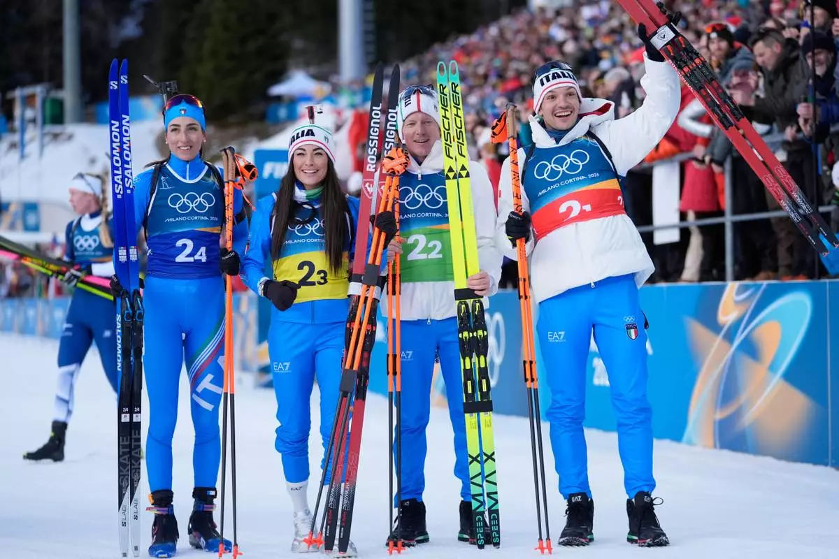 Italy's Lisa Vittozzi, from left, Dorothea Wierer, Lukas Hofer and Tommaso Giacomel celebrate winning silver in the 4X6-kilometer mixed relay biathlon race at the 2026 Winter Olympics in Anterselva, Italy, Sunday, Feb. 8, 2026. (AP Photo/Andrew Medichini)
