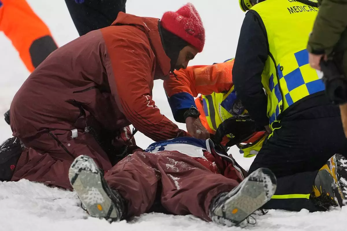 People tend to Canada's Mark McMorris after crashing during a snowboard big air training session at the 2026 Winter Olympics, in Livigno, Italy, Wednesday, Feb. 4, 2026. (AP Photo/Lindsey Wasson)