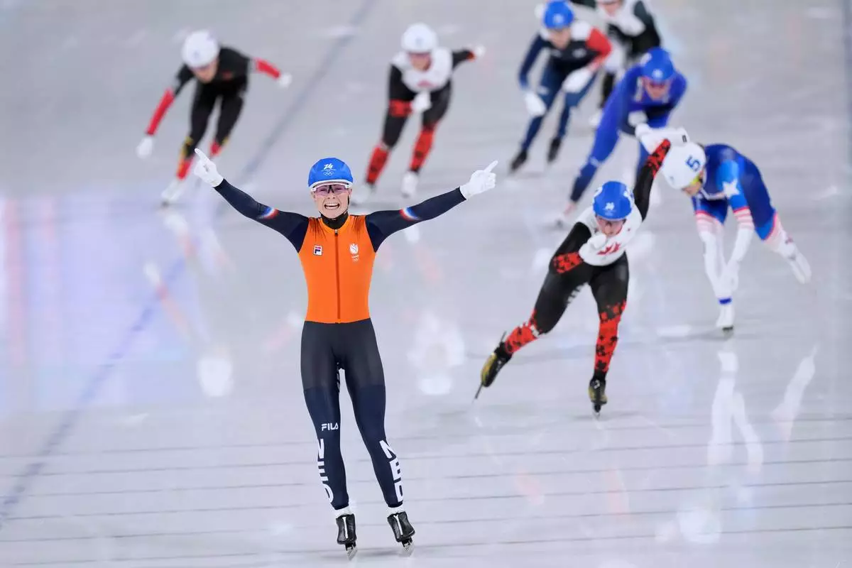 Marijke Groenewoud of the Netherlands celebrates winning the gold medal ahead of Ivanie Blondin of Canada, center right and silver medal, and Mia Manganello of the U.S., far right and bronze medal, in the women's mass start final speedskating race at the 2026 Winter Olympics, in Milan, Italy, Saturday, Feb. 21, 2026. (AP Photo/Luca Bruno)