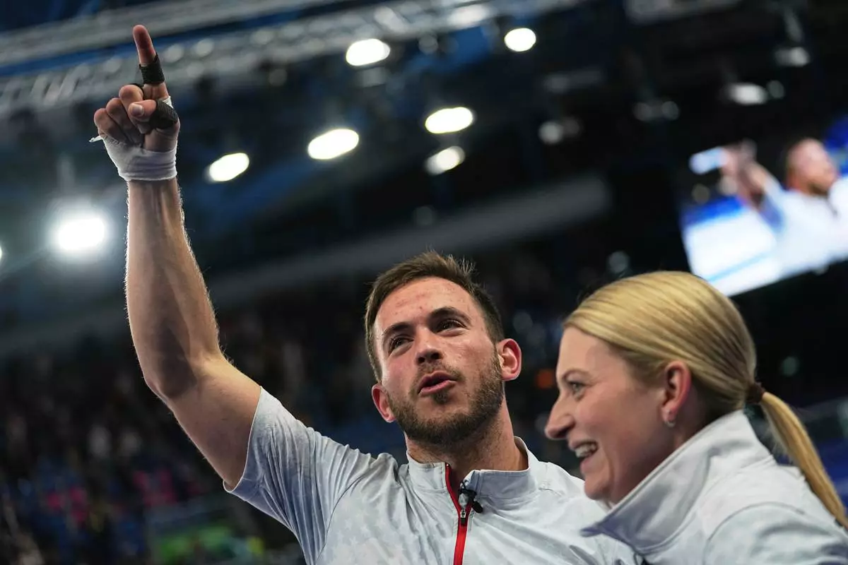 United States' Korey Dropkin, left, and United States' Cory Thiesse react following the semi-finals round of the mixed doubles curling match against Italy, at the 2026 Winter Olympics, in Cortina d'Ampezzo, Italy, Monday, Feb. 9, 2026. (AP Photo/Fatima Shbair)