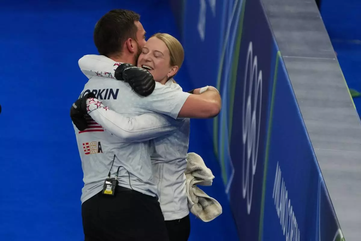 United States' Korey Dropkin and United States' Cory Thiesse hug after winning the semi-finals round of the mixed doubles curling match against Italy, at the 2026 Winter Olympics, in Cortina d'Ampezzo, Italy, Monday, Feb. 9, 2026. (AP Photo/Misper Apawu)