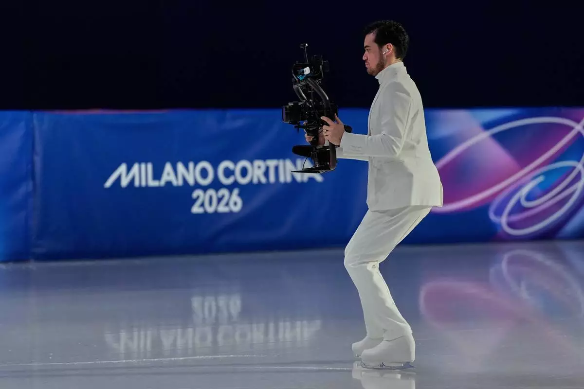 Jordan Cowan operates the steadicam before the pairs figure skating short program at the 2026 Winter Olympics, in Milan, Italy, Sunday, Feb. 15, 2026. (AP Photo/Ashley Landis)