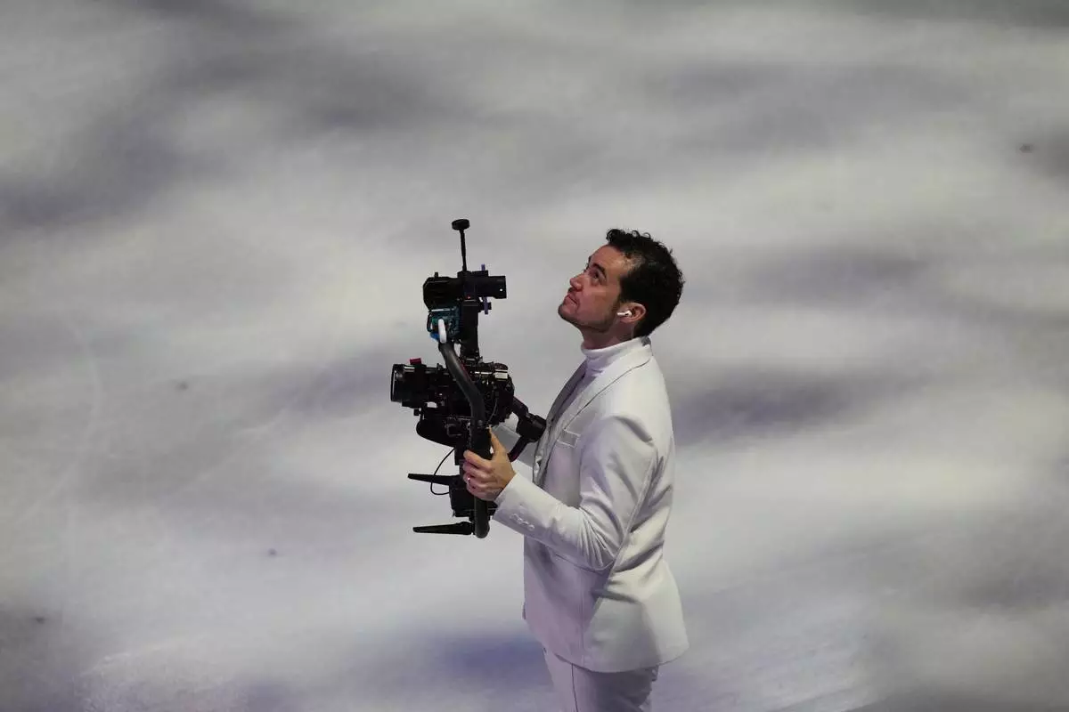 Jordan Cowan operates the steadicam before the pairs figure skating short program at the 2026 Winter Olympics, in Milan, Italy, Sunday, Feb. 15, 2026. (AP Photo/Stephanie Scarbrough)