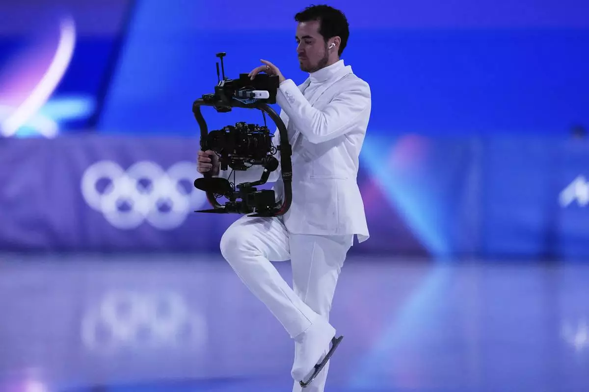 Jordan Cowan operates the steadicam before the pairs figure skating short program at the 2026 Winter Olympics, in Milan, Italy, Sunday, Feb. 15, 2026. (AP Photo/Ashley Landis)