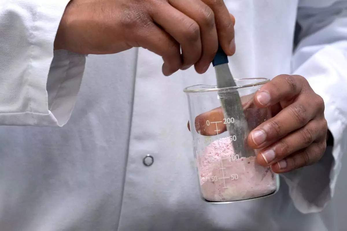 FILE - Applications Scientist Anuj Bag mixes coloring with flour at Sensient Technologies Corp., a color additive manufacturing company, April 2, 2025, in St. Louis. (AP Photo/Jeff Roberson, File)