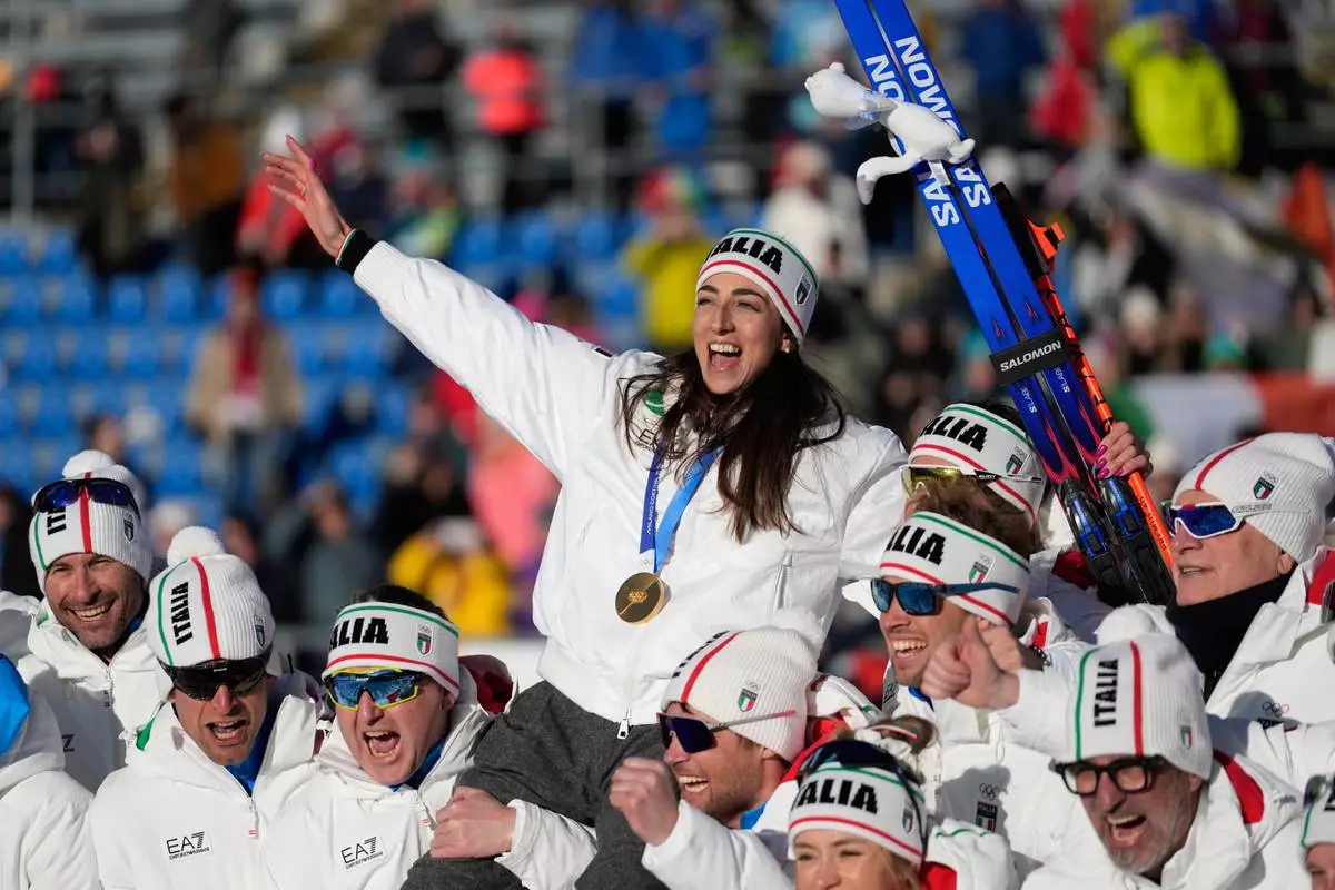 CORRECTS BYLINE: Gold medalist Lisa Vittozzi, of Italy, poses with teammates after the women's 10-kilometer pursuit biathlon race at the 2026 Winter Olympics in Anterselva, Italy, Sunday, Feb. 15, 2026. (AP Photo/Mosa'ab Elshamy)