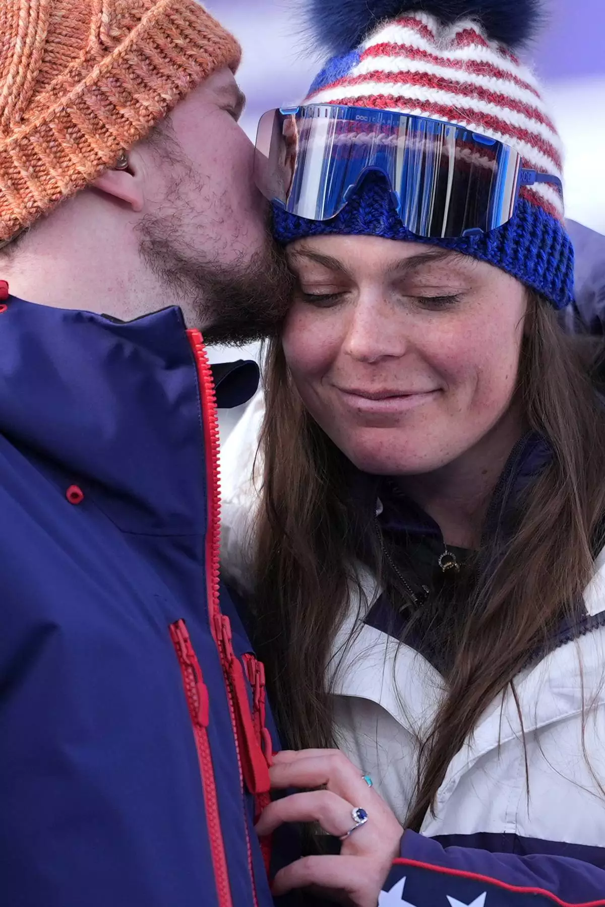 United States' Breezy Johnson, right, is kissed by fiancee Connor Watkins as they are interviewed after he proposed to her at the end of an alpine ski, women's super-G race, at the 2026 Winter Olympics, in Cortina d'Ampezzo, Italy, Thursday, Feb. 12, 2026. (AP Photo/Jacquelyn Martin)