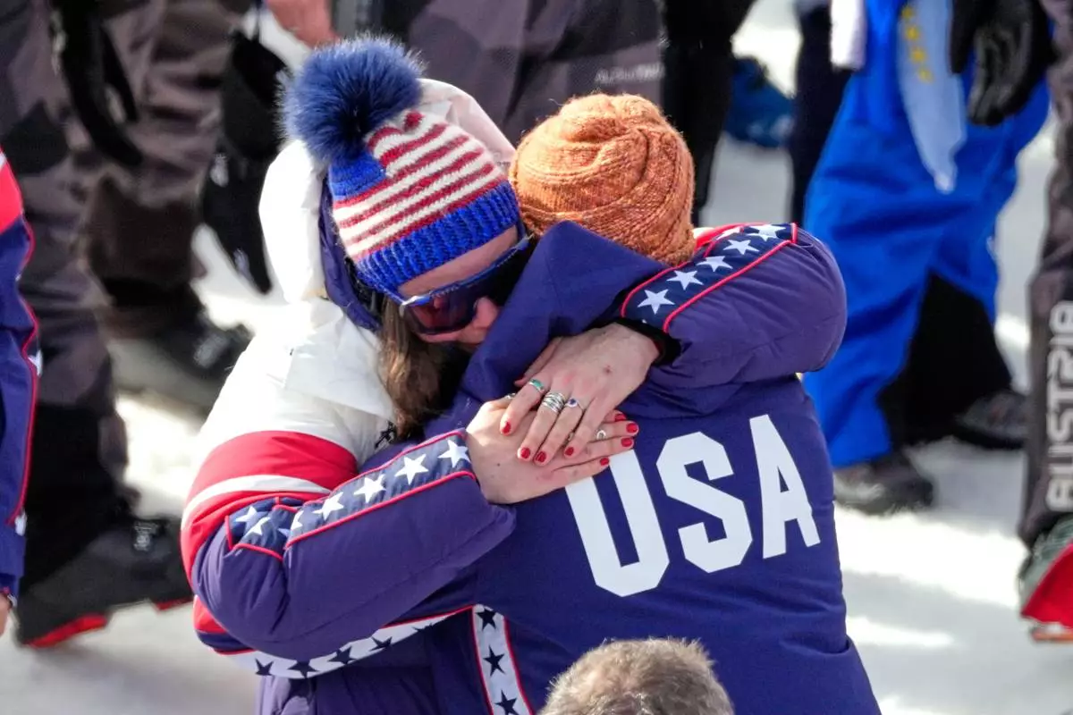 United States' Breezy Johnson hugs Connor Watkins, at the finish area of an alpine ski, women's super-G race, at the 2026 Winter Olympics, in Cortina d'Ampezzo, Italy, Thursday, Feb. 12, 2026. (AP Photo/Andy Wong)