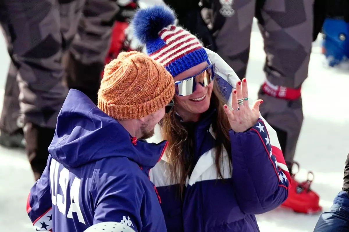 United States' Breezy Johnson looks at the engagement ring she was given by Connor Watkins, at the finish area of an alpine ski, women's super-G race, at the 2026 Winter Olympics, in Cortina d'Ampezzo, Italy, Thursday, Feb. 12, 2026. (AP Photo/Andy Wong)