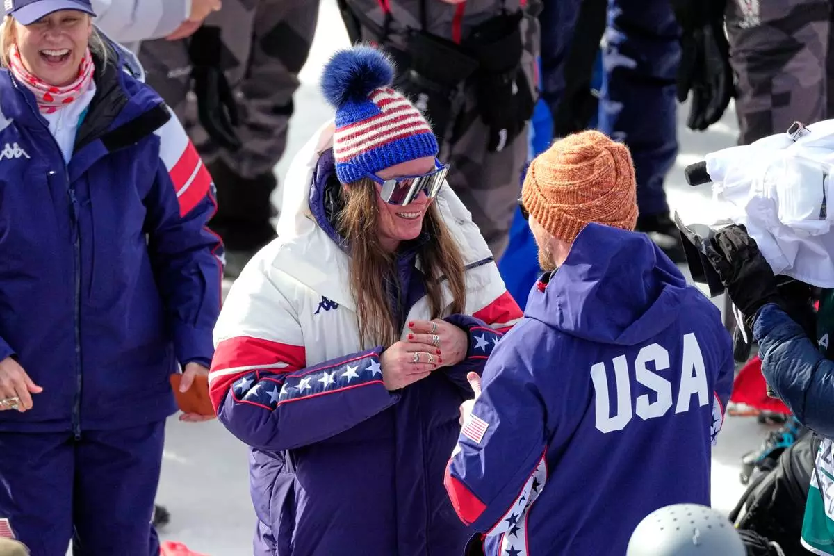 United States' Breezy Johnson touches the engagement ring she was given by Connor Watkins, at the finish area of an alpine ski, women's super-G race, at the 2026 Winter Olympics, in Cortina d'Ampezzo, Italy, Thursday, Feb. 12, 2026. (AP Photo/Andy Wong)