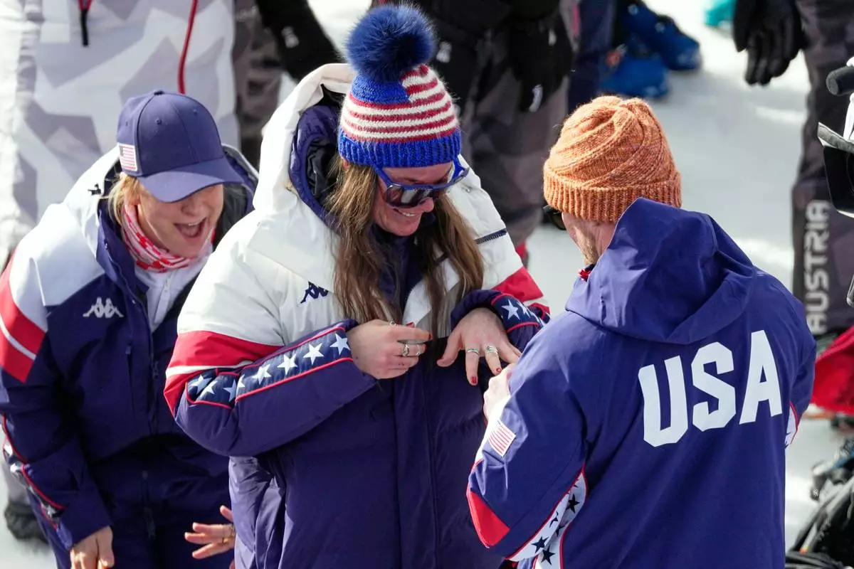 United States' Breezy Johnson looks at the engagement ring she was given by Connor Watkins, at the finish area of an alpine ski, women's super-G race, at the 2026 Winter Olympics, in Cortina d'Ampezzo, Italy, Thursday, Feb. 12, 2026. (AP Photo/Andy Wong)