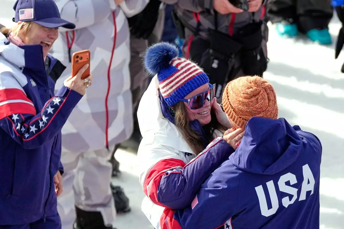 United States' Breezy Johnson looks at Connor Watkins after being given an engagement ring, at the finish area of an alpine ski, women's super-G race, at the 2026 Winter Olympics, in Cortina d'Ampezzo, Italy, Thursday, Feb. 12, 2026. (AP Photo/Andy Wong)