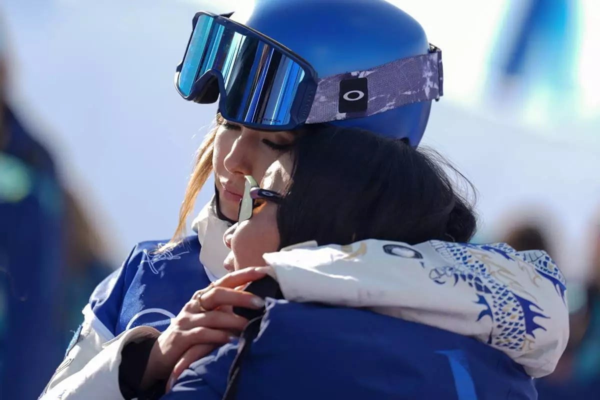 China's Eileen Gu hugs her mother, Yan Gu, during the women's freestyle skiing halfpipe final at the 2026 Winter Olympics, in Livigno, Italy, Sunday, Feb. 22, 2026. (AP Photo/Abbie Parr)