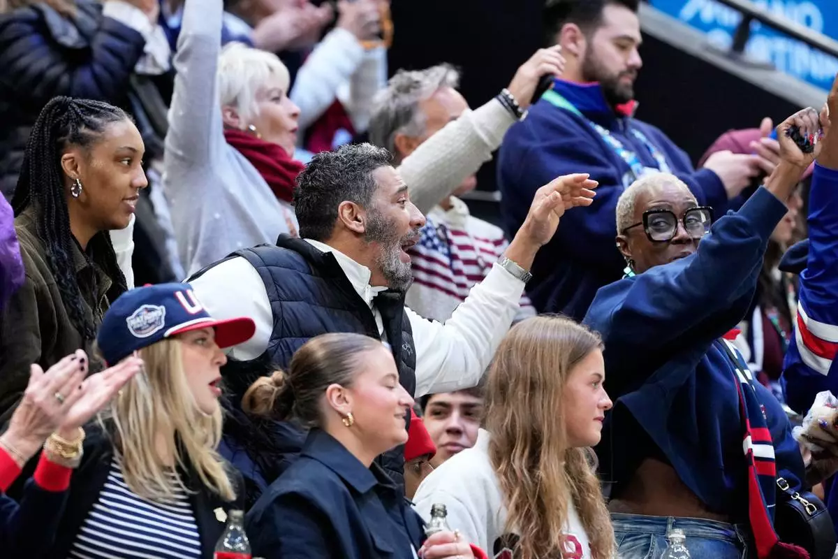 Family members of United States' Laila Edwards cheer during a women's ice hockey semifinal game between the United States and Sweden at the 2026 Winter Olympics, in Milan, Italy, Monday, Feb. 16, 2026. (AP Photo/Hassan Ammar)