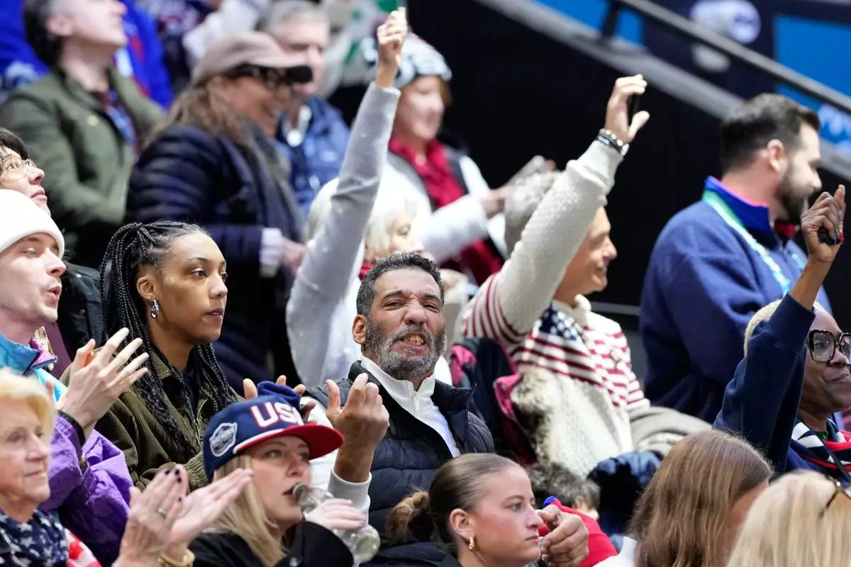 Robert Edwards, center, the father of United States' Laila Edwards cheers during a women's ice hockey semifinal game between the United States and Sweden at the 2026 Winter Olympics, in Milan, Italy, Monday, Feb. 16, 2026. (AP Photo/Hassan Ammar)