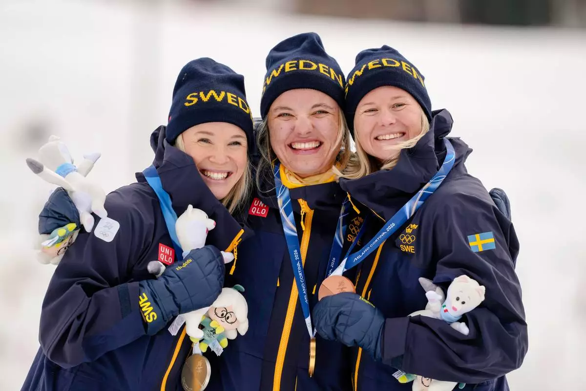 Gold medalist Linn Svahn, center, silver medalist Jonna Sundling, left, and bronze medalist Maja Dahlqvist, all three of Sweden, pose together after the cross-country skiing women's sprint classic at the 2026 Winter Olympics, in Tesero, Italy, Tuesday, Feb. 10, 2026. (AP Photo/Evgeniy Maloletka)