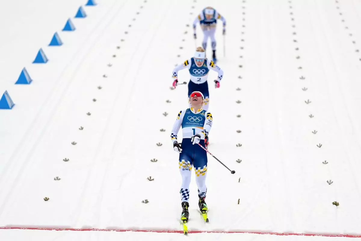 Linn Svahn, of Sweden, crosses the finish line ahead of Jonna Sundling, and Maja Dahlqvist, both also of Sweden, to win the gold medal in cross-country skiing women's sprint classic at the 2026 Winter Olympics, in Tesero, Italy, Tuesday, Feb. 10, 2026. (AP Photo/Matthias Schrader)