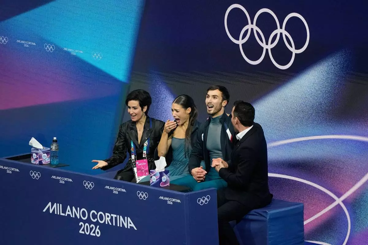 Laurence Fournier Beaudry and Guillaume Cizeron of France react to their scores after competing during the ice dancing free skate in figure skating at the 2026 Winter Olympics, in Milan, Italy, Wednesday, Feb. 11, 2026. (AP Photo/Natacha Pisarenko)