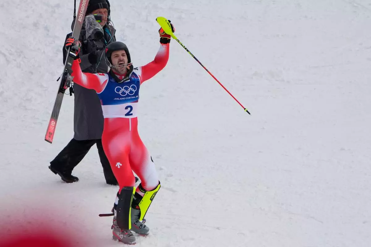 Switzerland's Loic Meillard celebrates winning an alpine ski, men's slalom race, at the 2026 Winter Olympics, in Bormio, Italy, Monday, Feb. 16, 2026. (AP Photo/John Locher)