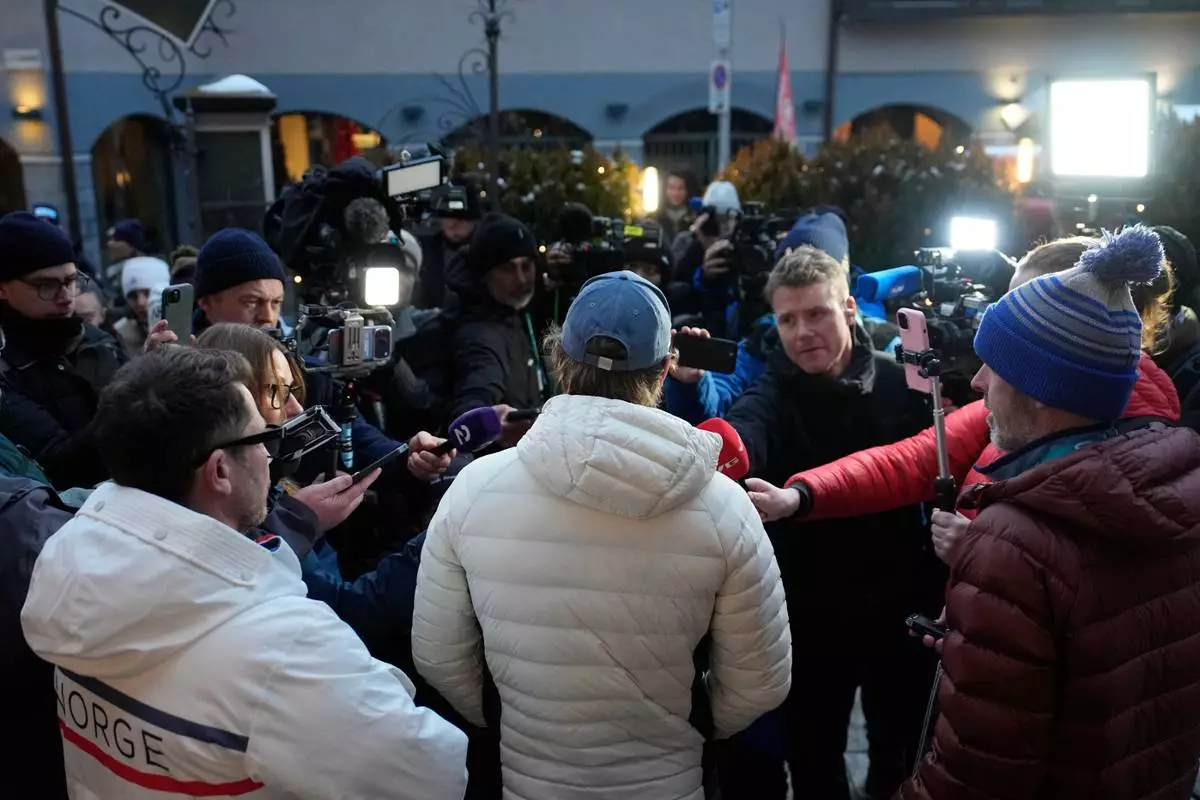 Norway's Atle Lie McGrath, center with back to camera, meets the media outside his hotel following an alpine ski, men's slalom race, at the 2026 Winter Olympics, in Bormio, Italy, Monday, Feb. 16, 2026. (AP Photo/John Locher)
