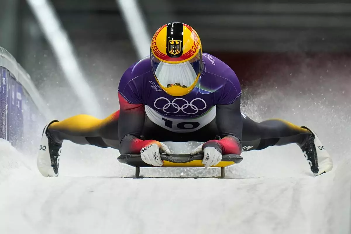 Germany's Axel Jungk arrives at the finish during a men's skeleton run at the 2026 Winter Olympics, in Cortina d'Ampezzo, Italy, Thursday, Feb. 12, 2026. (AP Photo/Alessandra Tarantino)