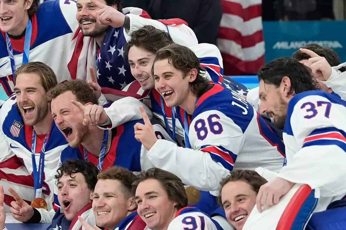 United States' Jack Hughes (86) poses with teammates after a men's ice hockey gold medal game between Canada and the United States at the 2026 Winter Olympics, in Milan, Italy, Sunday, Feb. 22, 2026. (AP Photo/Petr David Josek)