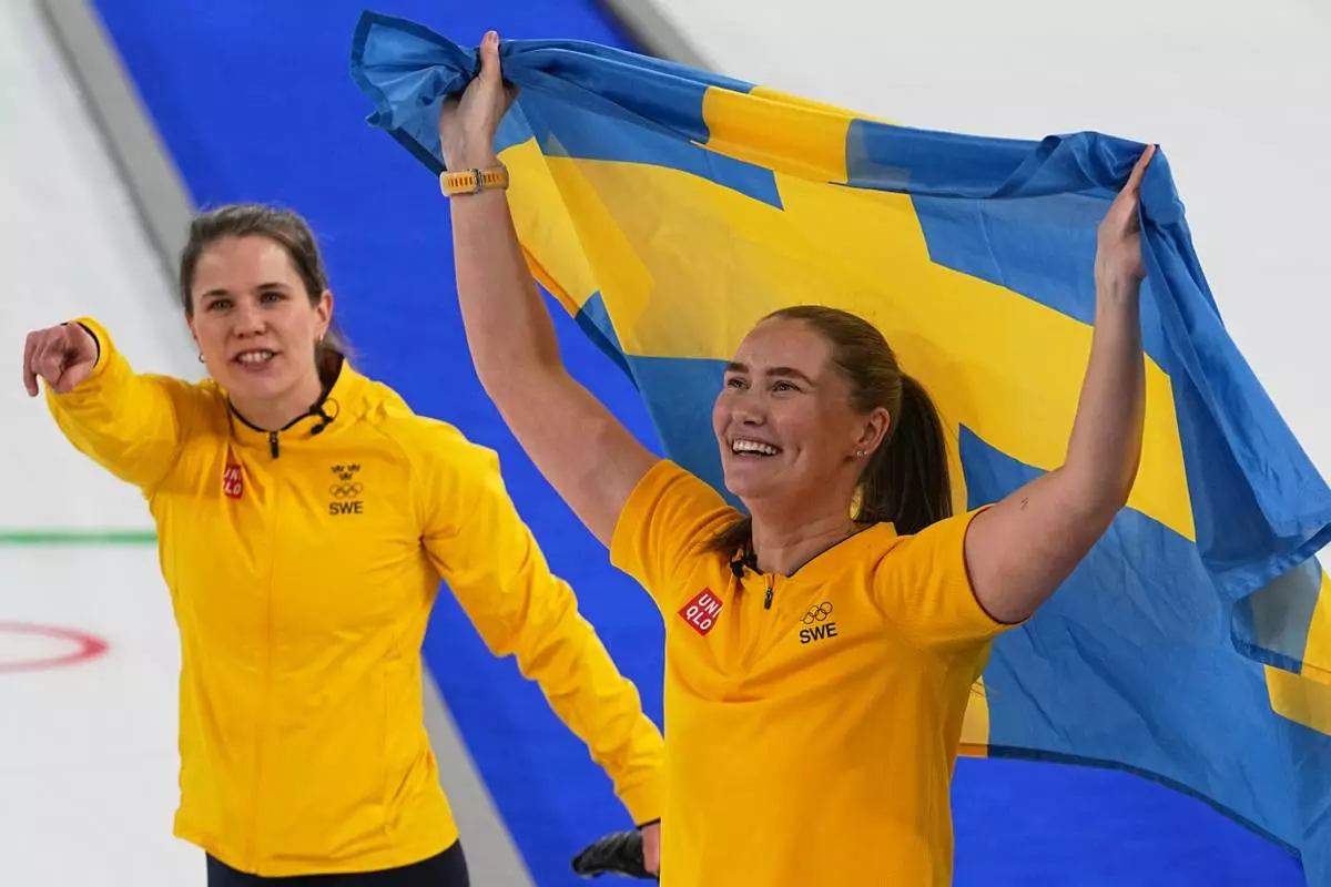 Sweden's Anna Hasselborg, left, and Sara McManus celebrate winning a women's curling gold medal match between Switzerland and Sweden, at the 2026 Winter Olympics, in Cortina d'Ampezzo, Italy, Sunday, Feb. 22, 2026. (AP Photo/Fatima Shbair)