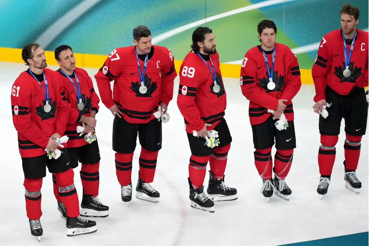 Canada's Sidney Crosby (87) stands with his teammates during the medal ceremony following Canada's overtime loss to the United States in the men's ice hockey gold medal game at the 2026 Winter Olympics in Milan, Italy, Sunday, Feb. 22, 2026. (AP Photo/Carolyn Kaster)