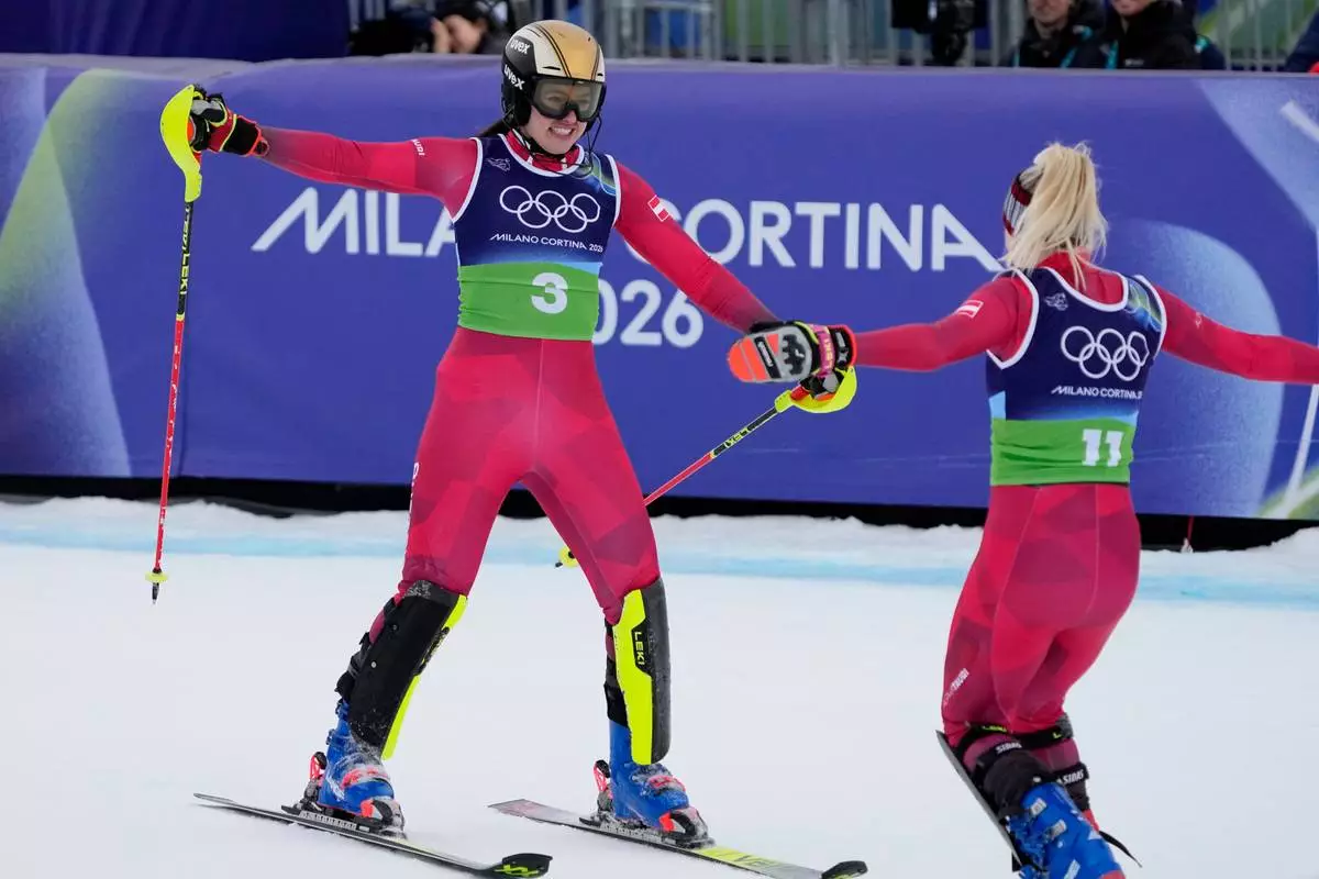 Austria's Katharina Huber, left, celebrates with Austria's Katharina Truppe at the finish area of an alpine ski, women's team combined race, at the 2026 Winter Olympics, in Cortina d'Ampezzo, Italy, Tuesday, Feb. 10, 2026. (AP Photo/Andy Wong)