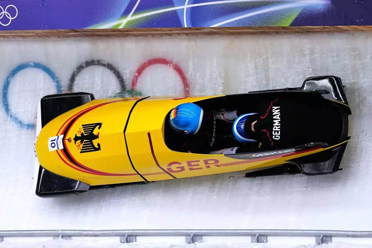 Germany's Francesco Friedrich, left, slides down the track during a two man bobsled training session at the 2026 Winter Olympics, in Cortina d'Ampezzo, Italy, Saturday, Feb. 14, 2026. (AP Photo/Aijaz Rahi)
