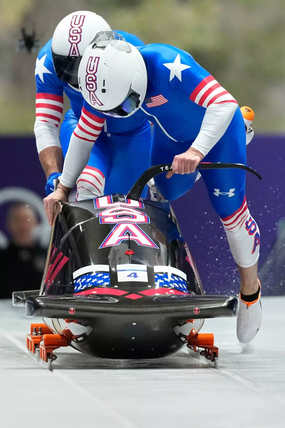 United States' Frankie del Duca, right, and Joshua Williamson start for a two man bobsled run at the 2026 Winter Olympics, in Cortina d'Ampezzo, Italy, Monday, Feb. 16, 2026. (AP Photo/Alessandra Tarantino)