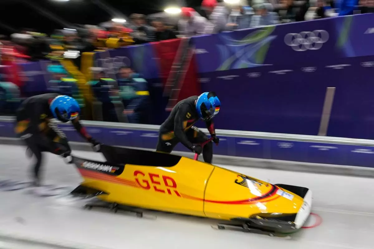 Germany's Adam Ammour, right, and Alexander Schaller start for a two man bobsled run at the 2026 Winter Olympics, in Cortina d'Ampezzo, Italy, Monday, Feb. 16, 2026. (AP Photo/Aijaz Rahi)