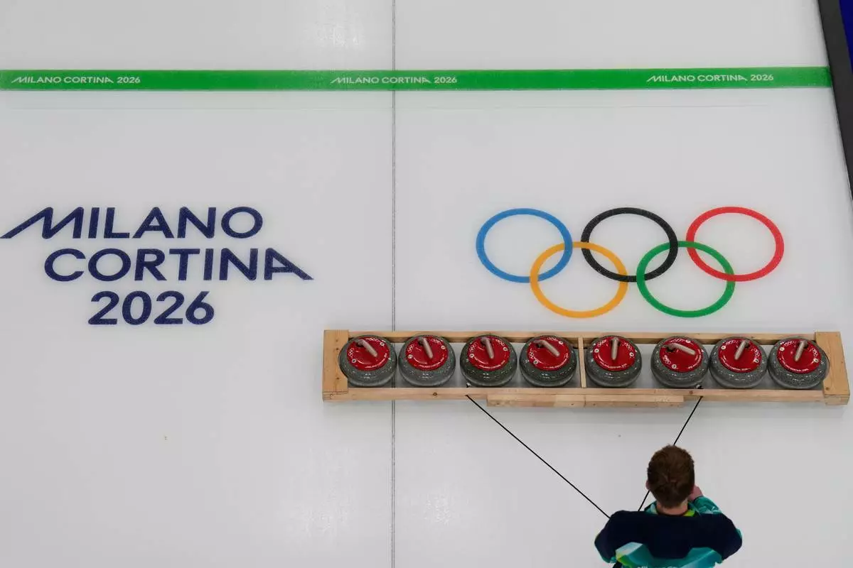 Curling stones are prepared ahead of a men's curling round robin session at the 2026 Winter Olympics, in Cortina d'Ampezzo, Italy, Wednesday, Feb. 11, 2026. (AP Photo/David J. Phillip)