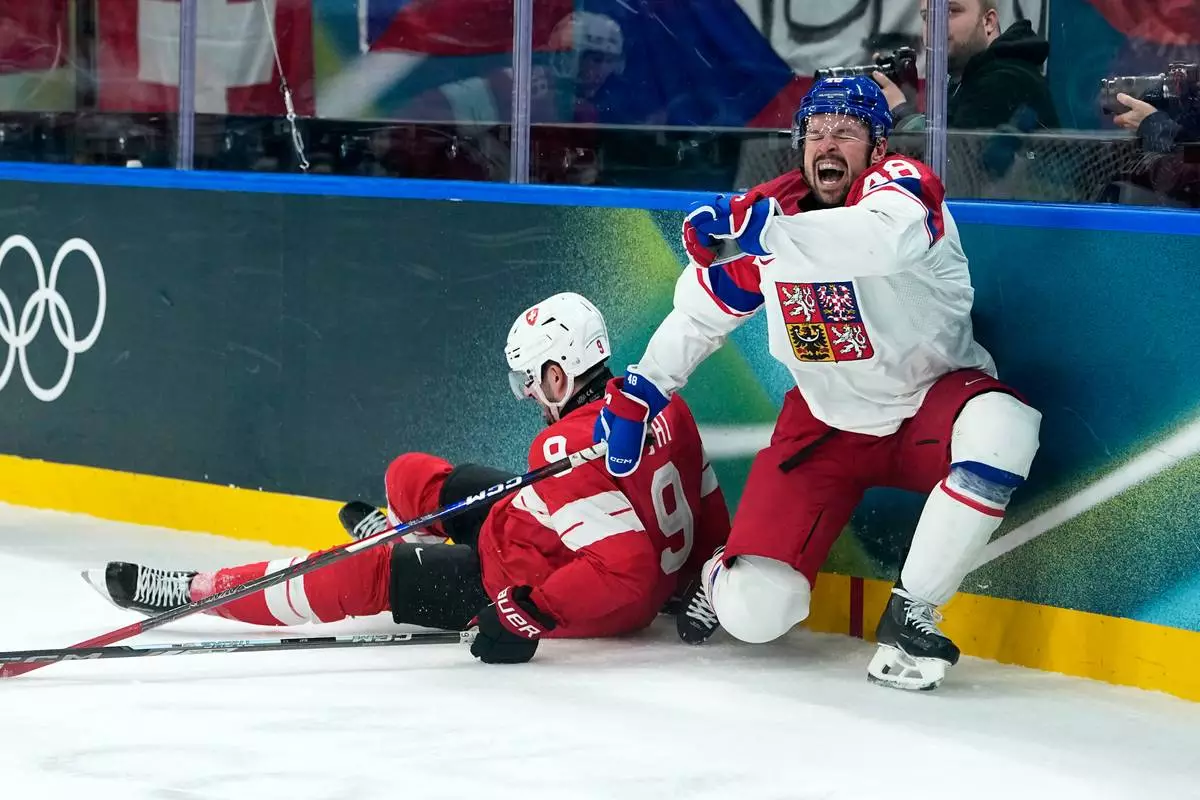 Czechia's Tomas Hertl (48) is challenged by Switzerland's Damien Riat (9) during a preliminary round match of men's ice hockey between Switzerland and Czechia at the 2026 Winter Olympics, in Milan, Italy, Sunday, Feb. 15, 2026. (AP Photo/Petr David Josek)