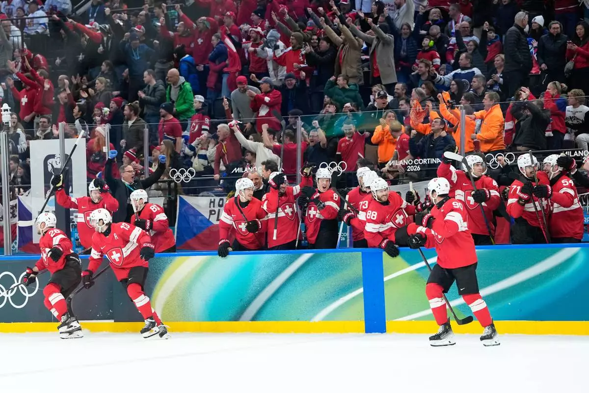 Switzerland players celebrate their victory after a preliminary round match of men's ice hockey between Switzerland and Czechia at the 2026 Winter Olympics, in Milan, Italy, Sunday, Feb. 15, 2026. (AP Photo/Petr David Josek)